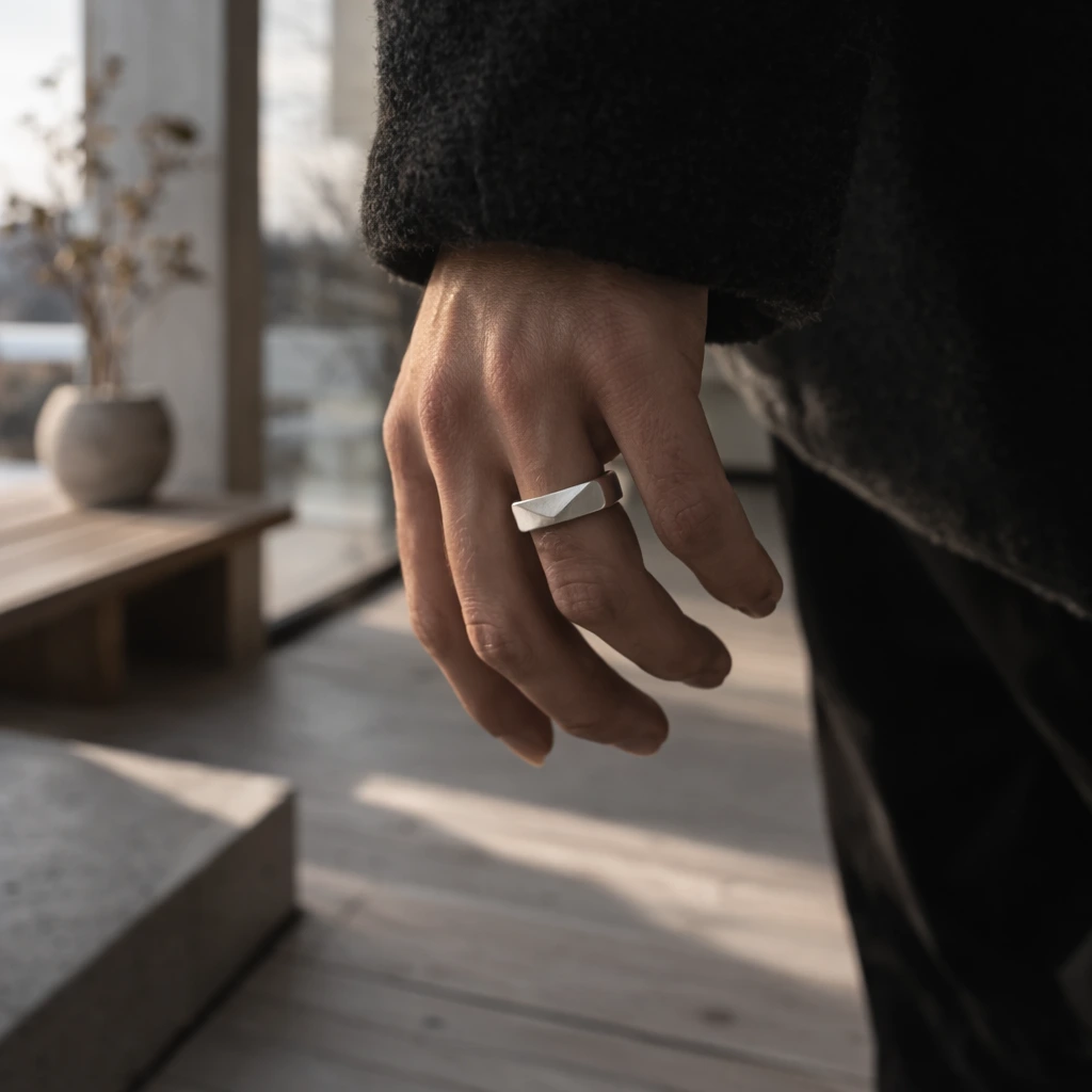 Geomtric silver ring on a hand. Scandinavian interior background
